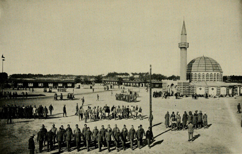 Halbmondlager, or “Half Moon Camp,”  a Muslim prisoner of war camp located in Wünsdorf, Germany, with mosque at right and prisoners drilled in military exercises in front. From the book, 