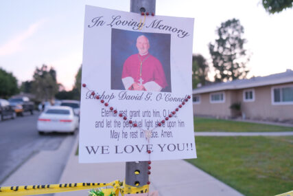A poster and rosary hang on a sign marked off with crime scene tape in memory of Bishop O'Connell on Sunday evening, Feb. 19, 2023, in Hacienda Heights. RNS photo by Alejandra Molina