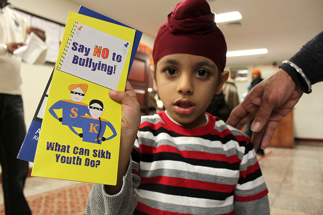 A child shows a Sikh anti-bullying brochure. Photo courtesy Sikh Coalition