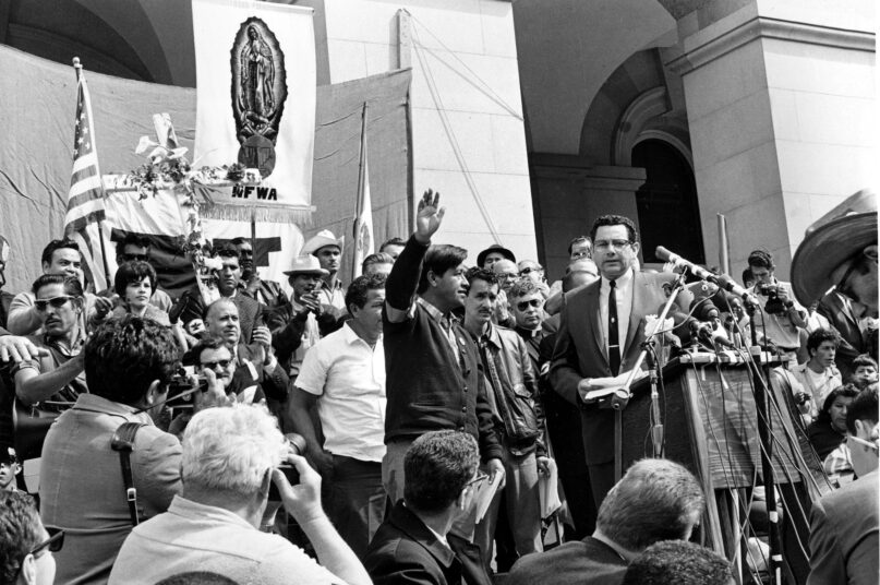 Cesar Chavez salutes the crowd on the steps of the California State Capitol. (AP Photo)