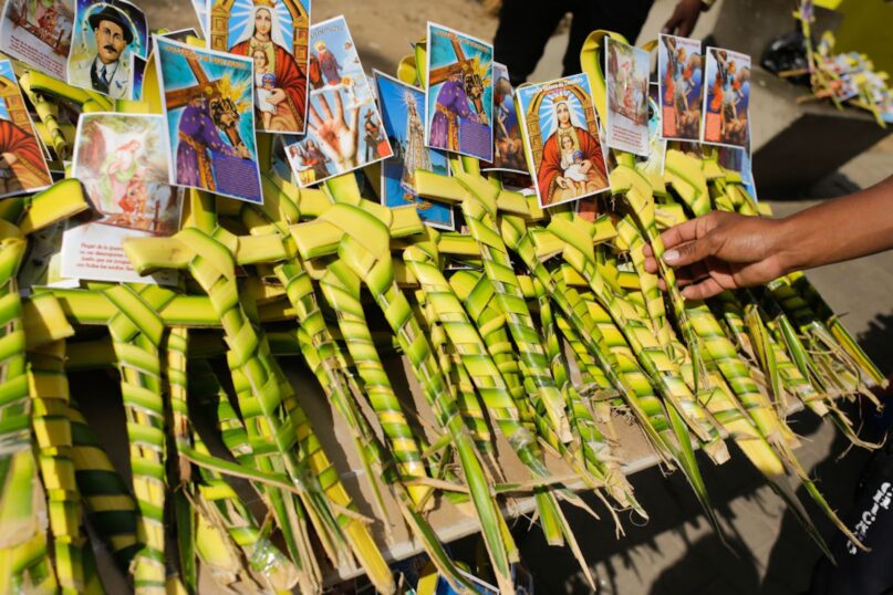 A man chooses a palm cross to buy on Palm Sunday near a church in Caracas, Venezuela, in 2022. (Javier Campos/NurPhoto via Getty Images)