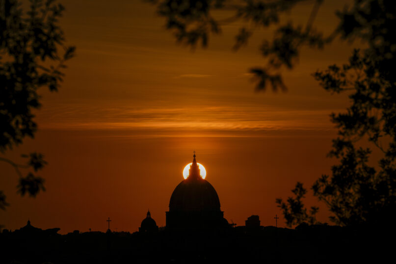 FILE - The sun sets behind the dome of St. Peter's Basilica, in Rome, on Feb. 20, 2023. (AP Photo/Andrew Medichini, File)