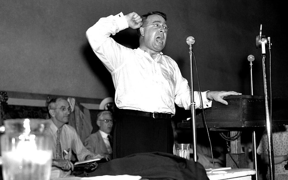 The Rev. Charles E. Coughlin, founder of the union for social justice, shed his coat and collar in the hot convention hall in Cleveland on July 17, 1936, as he attacked the Roosevelt administration before the Townsend National Convention. (AP Photo)
