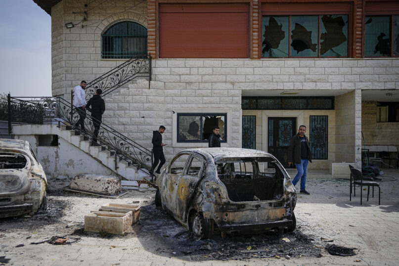 Palestinians inspect a damaged house and scorched cars in the town of Hawara, near the West Bank city of Nablus, Monday, Feb. 27, 2023. Scores of Israeli settlers went on a violent rampage in the northern West Bank, setting cars and homes on fire after two Israeli settlers were killed by a Palestinian gunman. Palestinian officials say one man was killed and four others were badly wounded. (AP Photo/Ohad Zwigenberg)