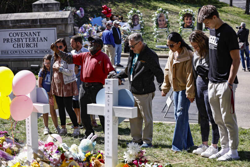 Fitzgerald Moore leads a group in prayer at a memorial at the entrance to The Covenant School on Wednesday, March 29, 2023, in Nashville, Tenn. (AP Photo/Wade Payne)