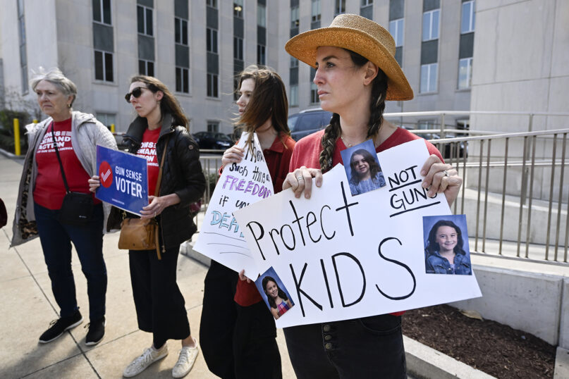 Lauren Giesler holds a sign with photos of her daughters as she joins other activist mothers at a rally at the state Capitol, March 28, 2023, in Nashville, Tennessee, the day after a shooting at a Christian elementary school in the city. (AP Photo/John Amis)