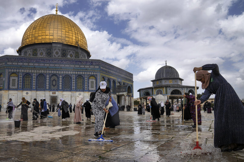 Palestinian volunteers clean the grounds outside the Dome of the Rock Mosque at the Al-Aqsa Mosque compound ahead of the Muslim holy month of Ramadan, in Jerusalem’s Old City, March 18, 2023. (AP Photo/Mahmoud Illean)