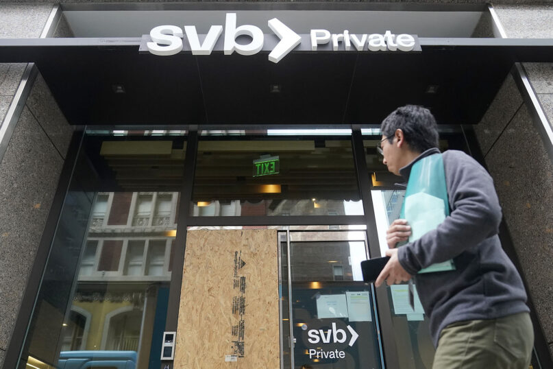 A pedestrian passes a Silicon Valley Bank branch in San Francisco, Monday, March 13, 2023. (AP Photo/Jeff Chiu)