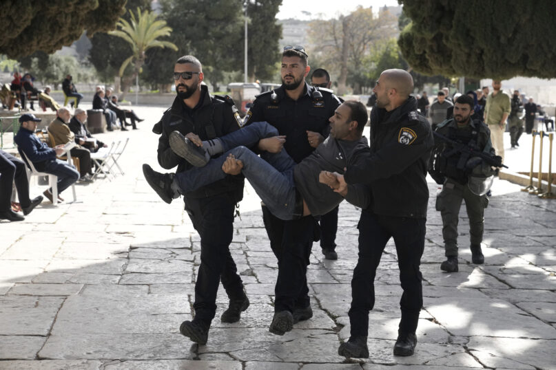 Israeli police detain a Palestinian in the Al-Aqsa Mosque compound following a raid of the site in the Old City of Jerusalem during the Muslim holy month of Ramadan, Wednesday, April 5, 2023. Palestinian media reported police attacked Palestinian worshippers, raising fears of wider tension as Islamic and Jewish holidays overlap.(AP Photo/Mahmoud Illean)