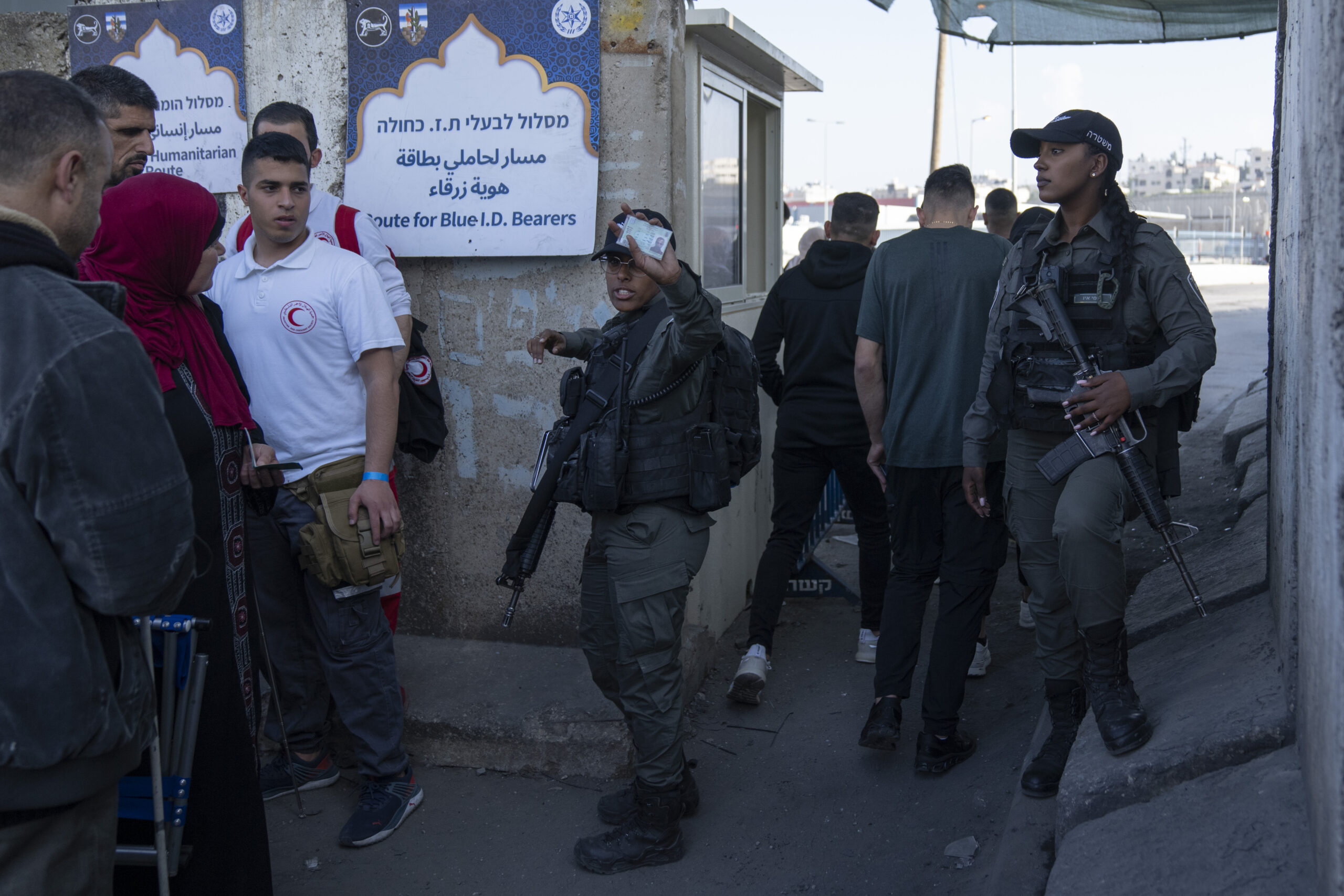 Israeli border police officers check identification cards of Palestinians while they try to cross from the occupied West Bank into Jerusalem, to pray during the holiest night of Ramadan, Laylat al-Qadr, or the "Night of Destiny," when Muslims believe that the Quran was revealed to the Prophet Mohammad, in the Al Aqsa mosque compound, at the Israeli military Qalandiya checkpoint, near Ramallah, Monday, April 17, 2023. Hundreds of thousands of Palestinians are barred from legally crossing into the contested capital, with most men under 55 years old turned away at checkpoints, and compelled to resort to other, perilous means to get to Al-Aqsa. (AP Photo/Nasser Nasser)