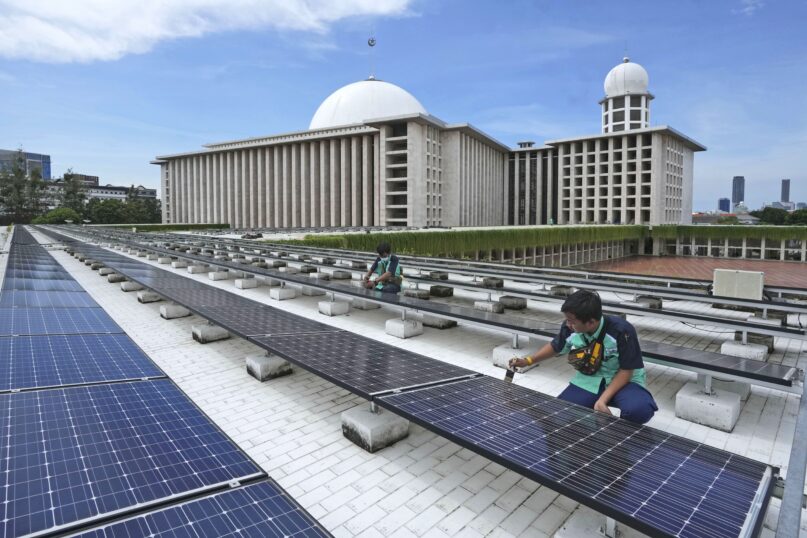 Workers perform maintenance work on solar panels that provide partial electrical power to Istiqlal Mosque in Jakarta, Indonesia, Wednesday, March 29, 2023. A major renovation in 2019 installed upwards of 500 solar panels on the mosque's expansive roof, now a major and clean source of Istiqlal's electricity. (AP Photo/Tatan Syuflana)
