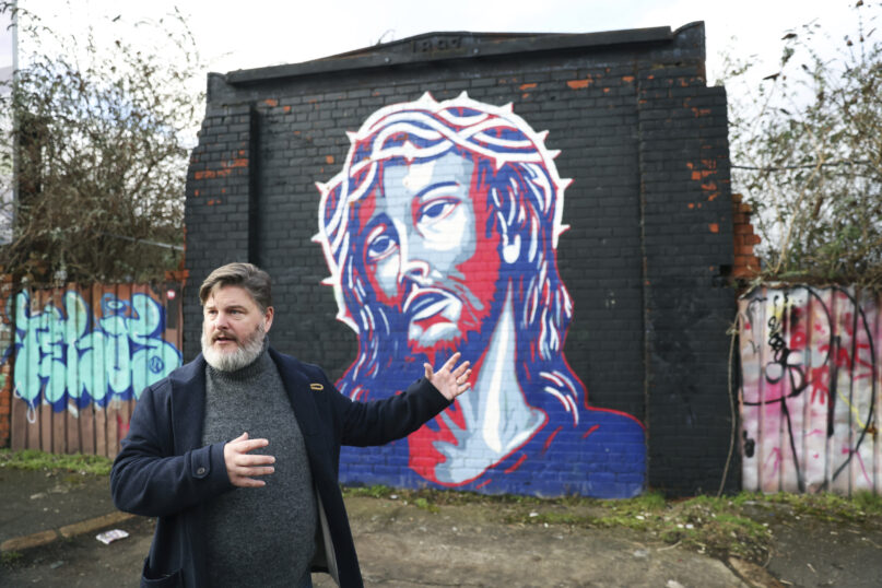 Jonny Clark, program manager for public theology at Corrmeela, an organisation that has worked for decades toward reconciliation in Northern Ireland, visits the peace walls in west Belfast, Northern Ireland, Saturday, Jan. 28, 2023. Twenty-five years ago, the Good Friday Agreement halted much of the violence of Northern Ireland’s Troubles. Today, grassroots faith leaders are trying to build on that opportunity. They're working toward reconciliation in a land where religion was often part of the problem. (AP Photo/Peter Morrison)