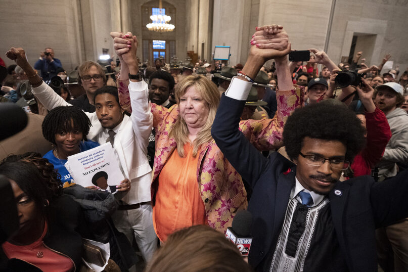 Former Rep. Justin Jones, D-Nashville, from left, Rep. Gloria Johnson, D-Knoxville, and former Rep. Justin Pearson, D-Memphis, raise their hands outside the House chamber after Jones and Pearson were expelled from the legislature Thursday, April 6, 2023, in Nashville, Tenn.  (AP Photo/George Walker IV)