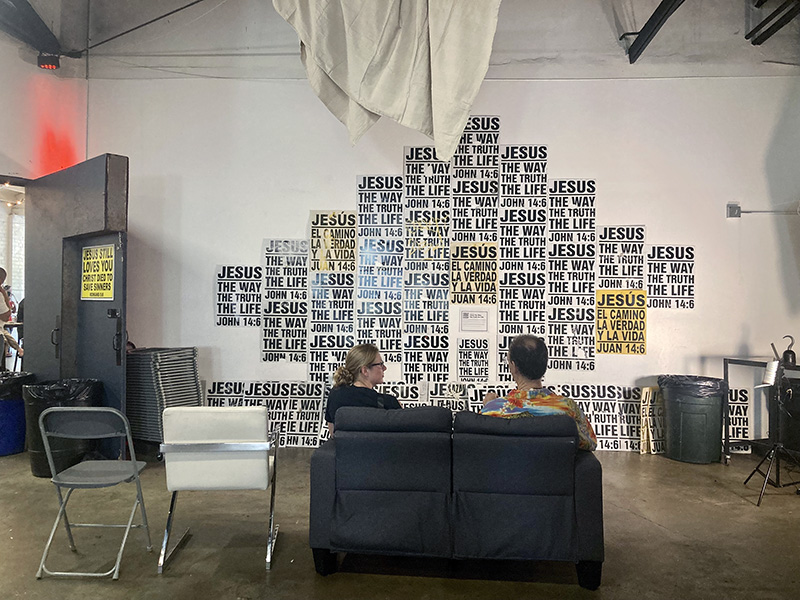 People attend an art exhibit hosted by Atheists United featuring religious signage that has been removed from streets in the Los Angeles area, Sunday, April 23, 2023, in Los Angeles. RNS photo by Alejandra Molina
