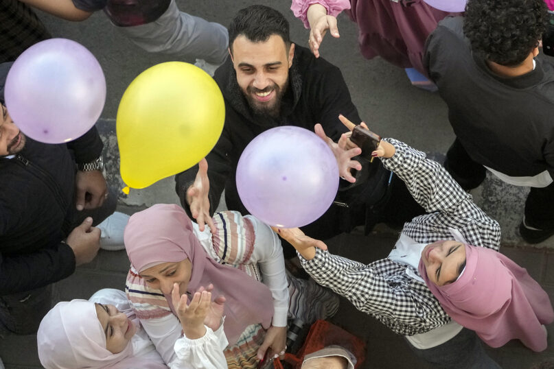 Egyptian Muslims try to catch balloons distributed for free after Eid al-Fitr prayers, marking the end of the Muslim holy fasting month of Ramadan, outside al-Seddik mosque in Cairo, Egypt, Friday, April 21, 2023. (AP Photo/Amr Nabil)