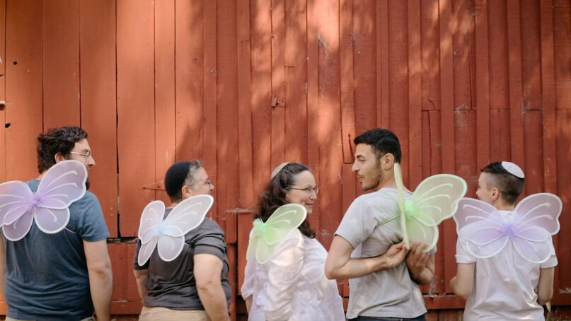 Participants in a Svara Queer Talmud Camp pose together while wearing wings in 2019. Video screen grab via Svara