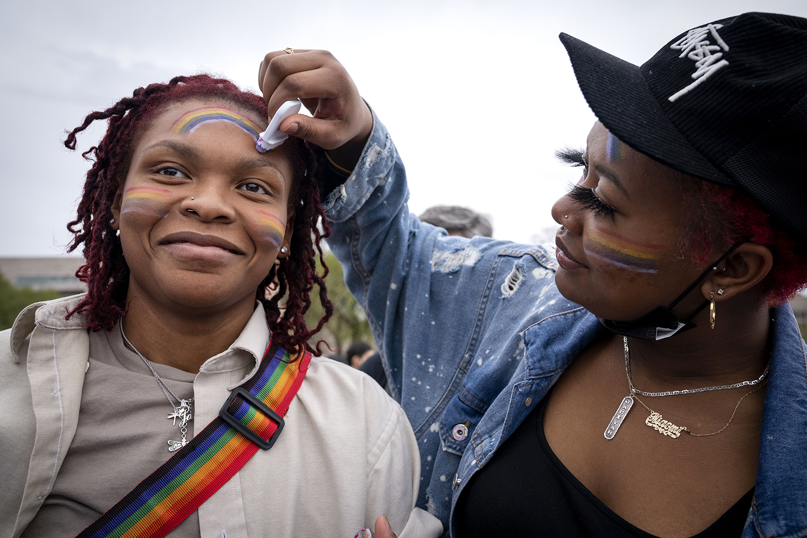Jamiyah Morrison, 19, of Riverdale, Md., left, has rainbow makeup touched up by Niaomi Moshier, 21, while attending a rally as part of Transgender Day of Visibility, Friday, March 31, 2023, near the Capitol in Washington. "I was never out as a child," says Morrison, "and didn't have the support. So what if my child identifies as trans? I need them to have the rights as well." (AP Photo/Jacquelyn Martin)