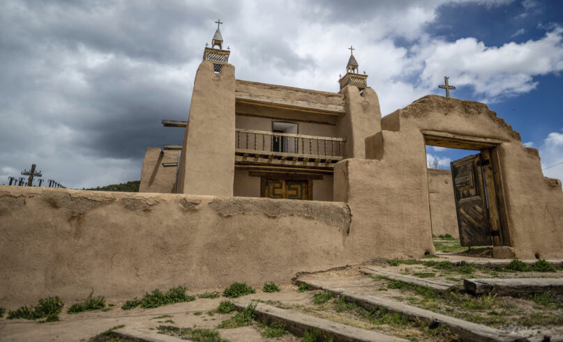 An exterior view of the San Jose de Gracia Catholic Church, built in 1760, in Las Trampas, New Mexico, Friday, April 14, 2023. Threatened by depopulation, dwindling congregations and fading traditions, some faithful are fighting to save their historic adobe churches and the uniquely New Mexican way of life they represent. (AP Photo/Roberto E. Rosales)