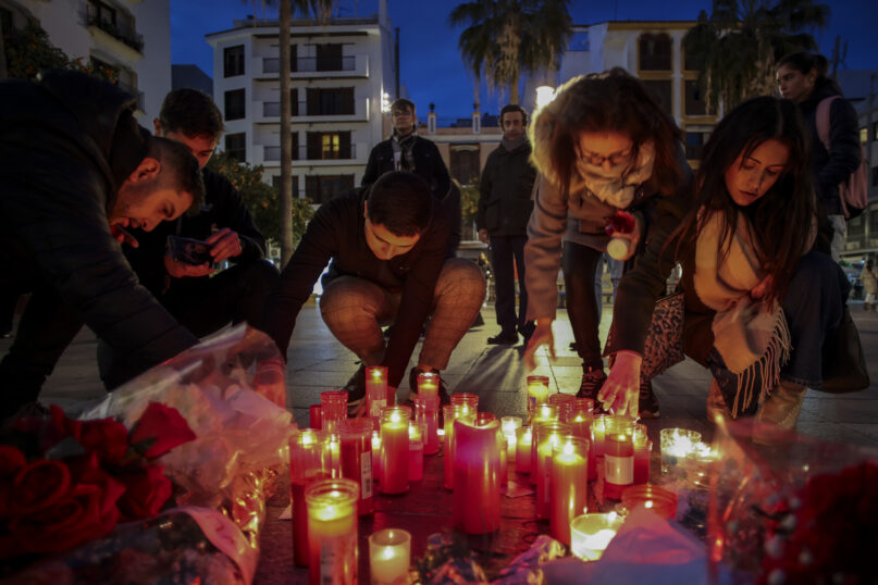 FILE - People light candles on Jan. 26, 2023, next to a memorial site for a church sacristan who was killed on Jan. 25 in Algeciras, southern Spain. Far-right groups have used Twitter to spread hate directed at Muslims and Immigrants. Many of them reference the Reconquista, the period in the Middle Ages that saw Christians retake vast parts of the Iberian peninsula from its Muslim leaders. The term has also been used by the Vox Party, a far-right party that has been praised by ex-U.S. President Donald Trump. (AP Photo/Juan Carlos Toro)