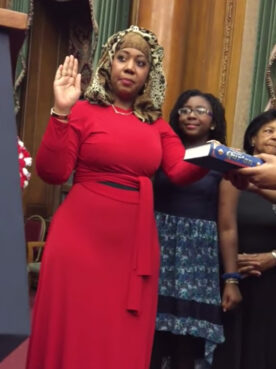 Carolyn Walker-Diallo, left, uses a Quran during to be sworn in as a New York civil judge in 2015. Video screen grab