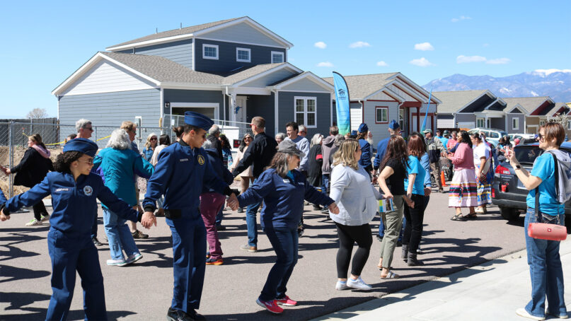 Attendees participate in a traditional round dance showcasing friendship, led by the Native American Women's Association, during the dedication of a Pikes Peak Habitat for Humanity Interfaith Build for Unity home, rear left, on April 29, 2023, in Colorado Springs, Colorado. Photo courtesy of Pikes Peak Habitat for Humanity