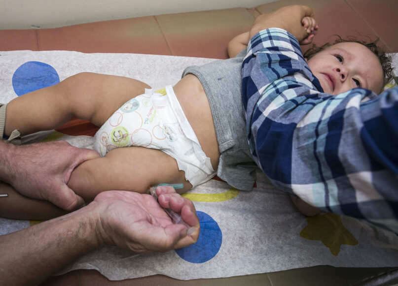 FILE - In this Jan. 29, 2015, file photo, pediatrician Charles Goodman vaccinates 1-year-old Cameron Fierro with the measles-mumps-rubella vaccine, or MMR vaccine, at his practice in Northridge, Calif. (AP Photo/Damian Dovarganes,File)