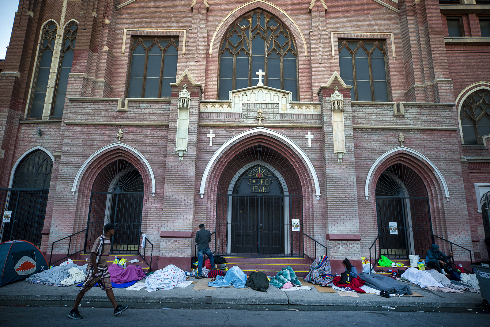 Migrants wake up at the sidewalk outside Sacred Heart Church in downtown El Paso, Texas, on Tuesday, May 9, 2023. As confusion over border rules explodes in El Paso, one of the busiest illegal crossing points for migrants seeking to flee poverty and political strife, faith leaders continue to provide shelter, legal advice and prayer. (AP Photo/Andres Leighton)