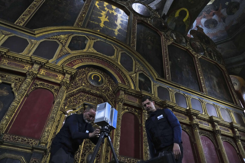 Volunteers Emmanuel Durand, left, and Serhii Revenko set up a high-tech scanner at the All Saints Church at the Kyiv-Pechersk Lavra in Kyiv, Ukraine, Sunday, June 11, 2023. Using high-tech laser gear, a United Nations-backed team is scanning Ukraine historical sites to preserve them amid Russia's war on the country. (AP Photo/Jon Gambrell)