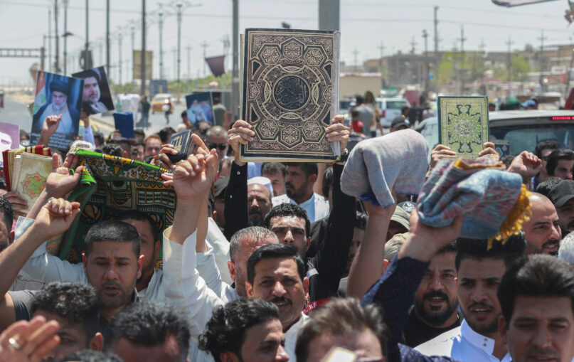 Supporters of the Shiite cleric Muqtada al-Sadr raise the Quran, the Muslim holy book, in response to the burning of a copy of the Quran in Sweden, during open-air Friday prayers in Basra, Iraq, Friday, June 30, 2023. (AP Photo/ Nabil al-Jurani)