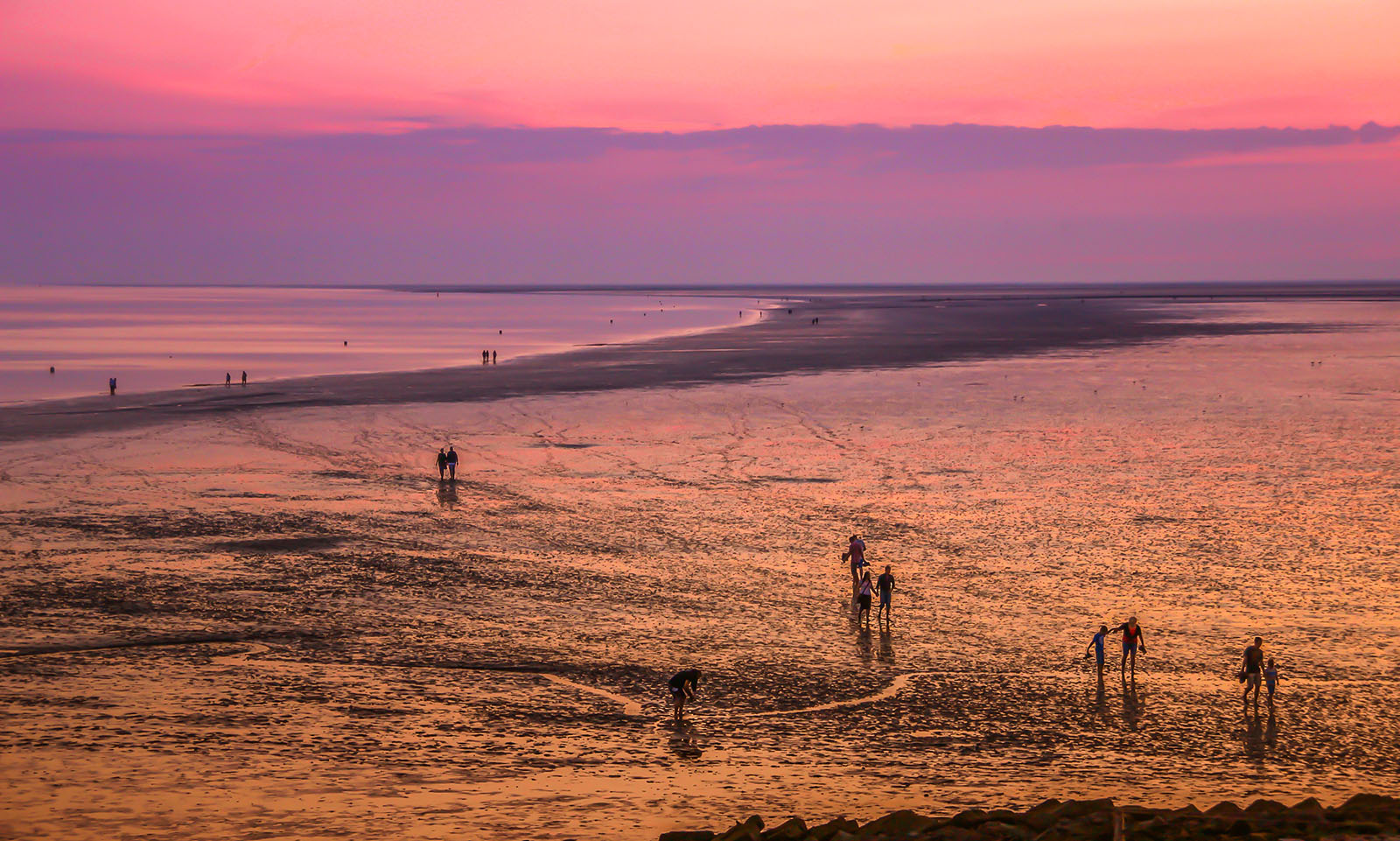People explore the Wadden Sea mudflats in northern Germany during a low tide. Photo by Tom/Pixabay/Creative Commons