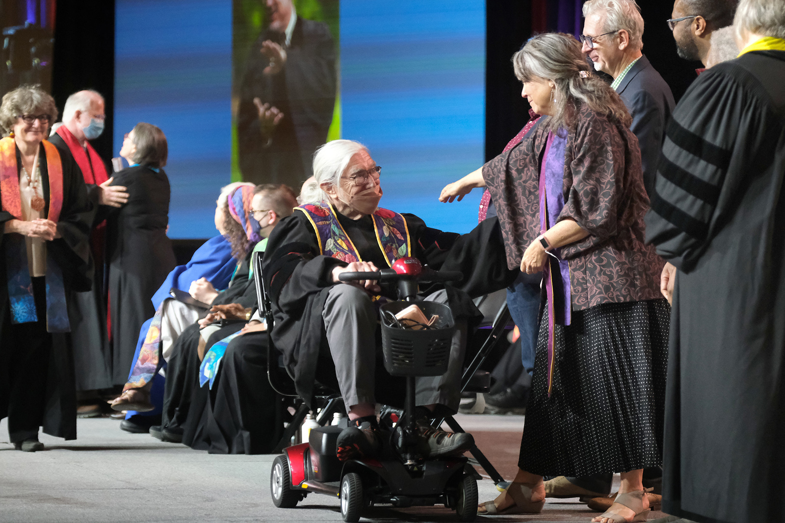 The Rev. Clyde Grubbs, center, crosses the stage as a religious professional completing service, greeted by Rev. Leslie Takahashi, President of UU Ministers Association, during the General Assembly, Thursday, June 22, 2023, in Pittsburgh, Pennsylvania. Photo © 2023 Nancy Pierce/UUA
