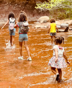 Brytni McNeil's four children hike through a shallow stream. McNeil's choice to homeschool her children stems from a hope to allow her kids not be shielded from the realities of race and truth, but to learn about and understand them on their own terms. Photo courtesy McNeil