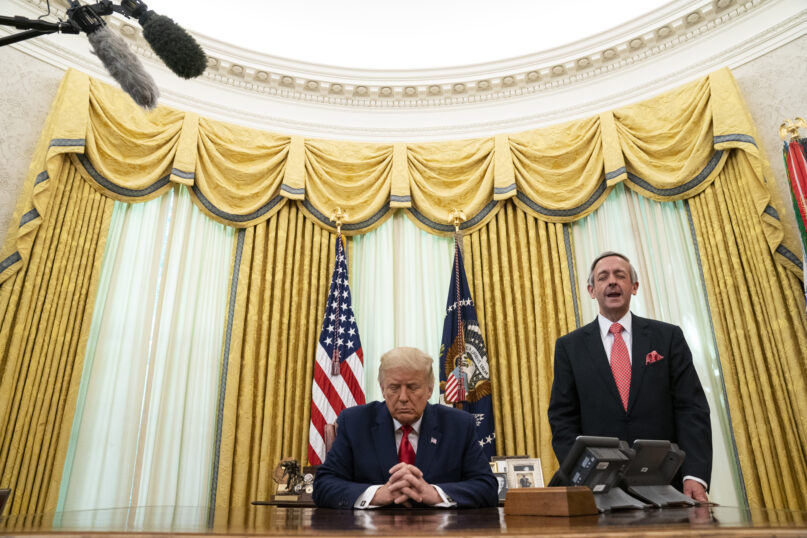 FILE - Pastor Robert Jeffress and President Donald Trump pray after Trump signed a full pardon for Alice Johnson in the Oval Office of the White House, Friday, Aug. 28, 2020, in Washington. Jeffress, pastor of an evangelical megachurch in Dallas, has been a staunch supporter of Trump since his first campaign for president. “Conservative Christians continue to overwhelmingly support Donald Trump because of his biblical policies, not his personal piety,” Jeffress told The Associated Press via email. (AP Photo/Evan Vucci, File)