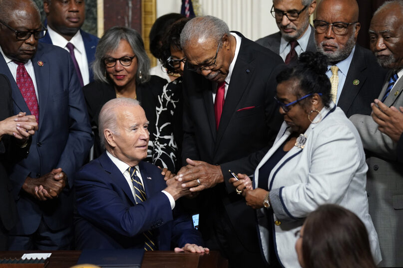 President Joe Biden shakes hands with the Rev. Wheeler Parker Jr. as Marvel Parker holds a signing pen at right, after Biden signed a proclamation to establish the Emmett Till and Mamie Till-Mobley National Monument, in the Indian Treaty Room on the White House campus, July 25, 2023, in Washington. (AP Photo/Evan Vucci)