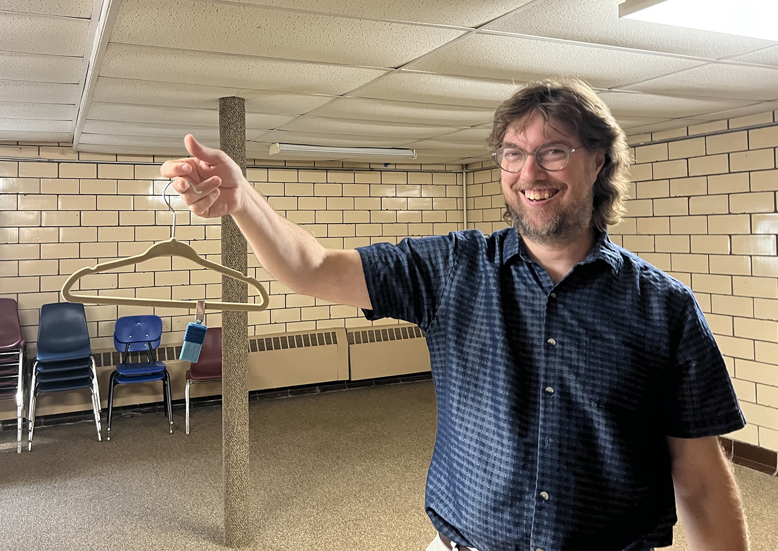 The Rev. Fritz Nelson removes a passive air sampling device, attached to hanger, from the basement of First United Presbyterian Church in East Palestine, Ohio, Monday, July 17, 2023. RNS photo by Kathryn Post