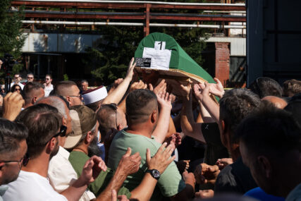 The crowd of attendees at the Srebrenica Genocide Commemoration lift the first coffin of remains overhead outside the memorial center in early July in Bosnia. Photo by Shahar Azran/WJC