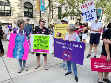Beth Welton of Chapel Hill's Church of Reconciliation holds a sign that reads "Women of Faith of Oppose SB 20" the new North Carolina law banning abortion after 12 weeks of pregnancy. Welton demonstrated against the law in Raleigh, the state capitol, in June. Photo courtesy Beth Welton