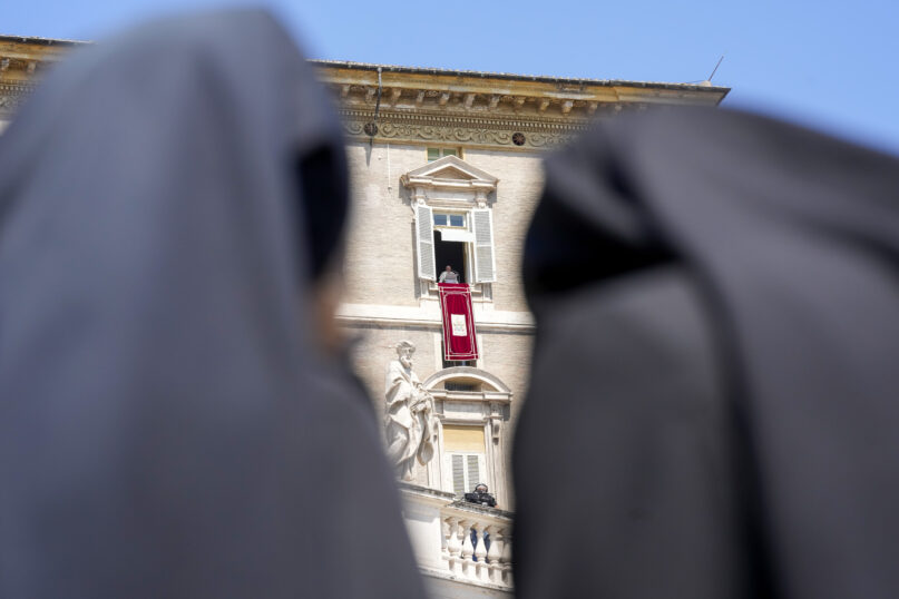 Nuns look at Pope Francis as he recites the Angelus noon prayer from the window of his studio overlooking St.Peter's Square, at the Vatican, Sunday, Aug. 20, 2023. (AP Photo/Andrew Medichini)