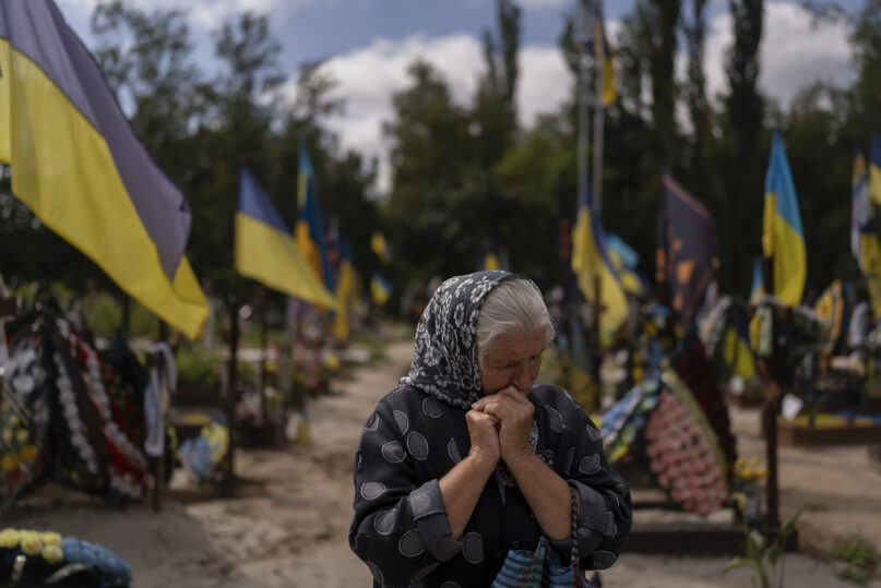 Svitlana Sushko, 62, sobs while visiting the grave of her youngest son, a Ukrainian soldier who was killed last year in the war against Russia, in Kyiv, Ukraine, Thursday, Aug. 3, 2023. (AP Photo/Jae C. Hong)