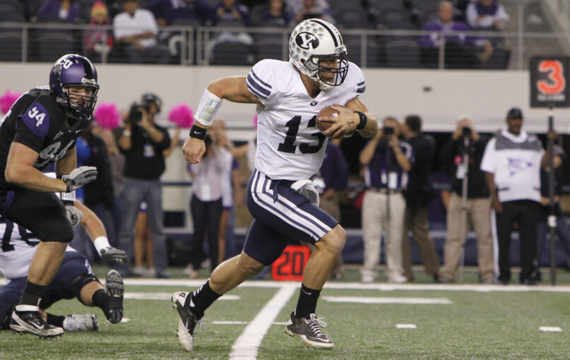 FILE - BYU quarterback Riley Nelson (13) rushes the ball past TCU defensive tackle D.J. Yendrey (94) during the first half of an NCAA college football game at Cowboys Stadium, Oct. 28, 2011, in Arlington, Texas. With BYU coming in this season, the Big 12 has three private Christian schools from different denominations that are playing major college football. After the past 12 seasons as an independent, the Cougars are now in the same league with Baylor and TCU — whose 118-game “Revivalry” dates back to a scoreless tie in 1899. (AP Photo/LM Otero, File)