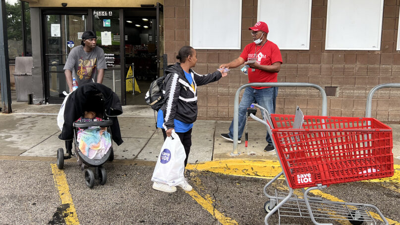 Elder Richard Daniel, right, of Greater Love Missionary Baptist Church, passes out voting literature while canvassing at a grocery store with Faith Community United in Cleveland, Aug. 7, 2023. RNS photo by Kathryn Post