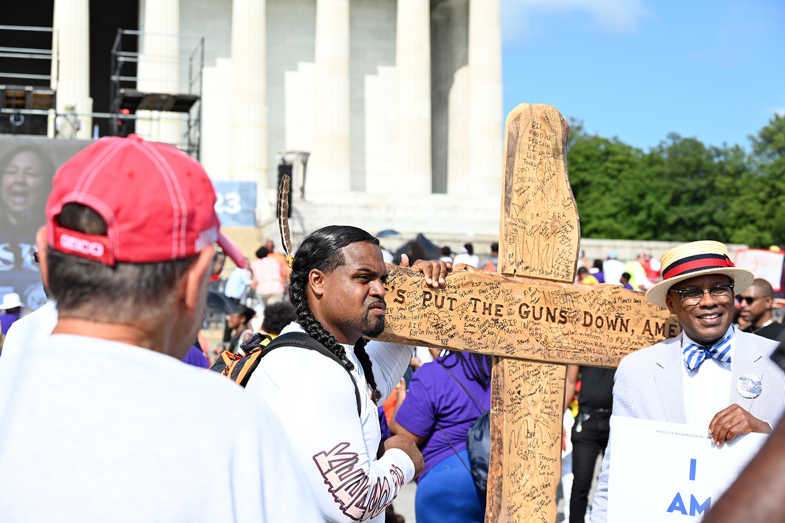 An attendee carries a large, wooden cross during 60th anniversary of the March on Washington at the Lincoln Memorial in Washington, D.C., on Aug. 26, 2023. RNS photo by Jack Jenkins.