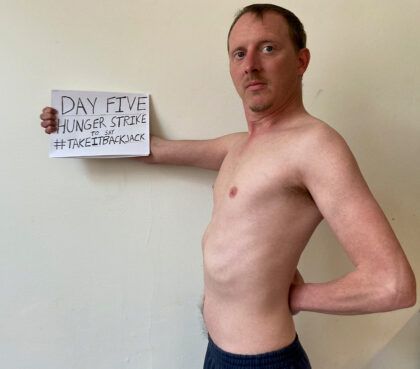 Pieter Friedrich holds a sign during his recent hunger strike. Courtesy photo