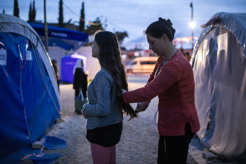 Kader Mersin combs her daughter Atra Basak’s hair next to tents where they temporarily live after February’s powerful earthquake in Antakya, southeastern Turkey, May 9, 2023. (AP Photo/Metin Yoksu)
