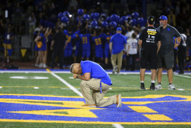 FILE - Bremerton High School assistant coach Joe Kennedy takes a knee and prays at the 50-yard line after Bremerton's win over Mount Douglas in a high school football game at Bremerton Memorial Stadium in Bremerton, Wash., on Sept. 1, 2023. Kennedy, the praying football coach who had a long legal battle to get his job back, resigned Wednesday, Sept. 6, 2023, after his first game back on the job. He cited multiple reasons for his resignation including taking care of an ailing family member out of state. (Meegan M. Reid/Kitsap Sun via AP, File)
