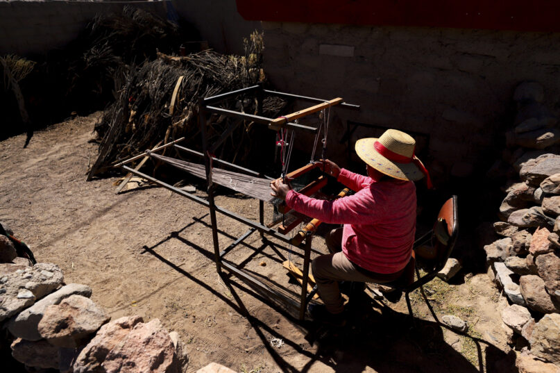 Teófila Challapa weaves on her loom at home in Cariquima, Chile, Monday, July 31, 2023. Challapa, 59, prays before beginning her work: “Mother Earth, give me strength, because you're the one who will produce, not me.