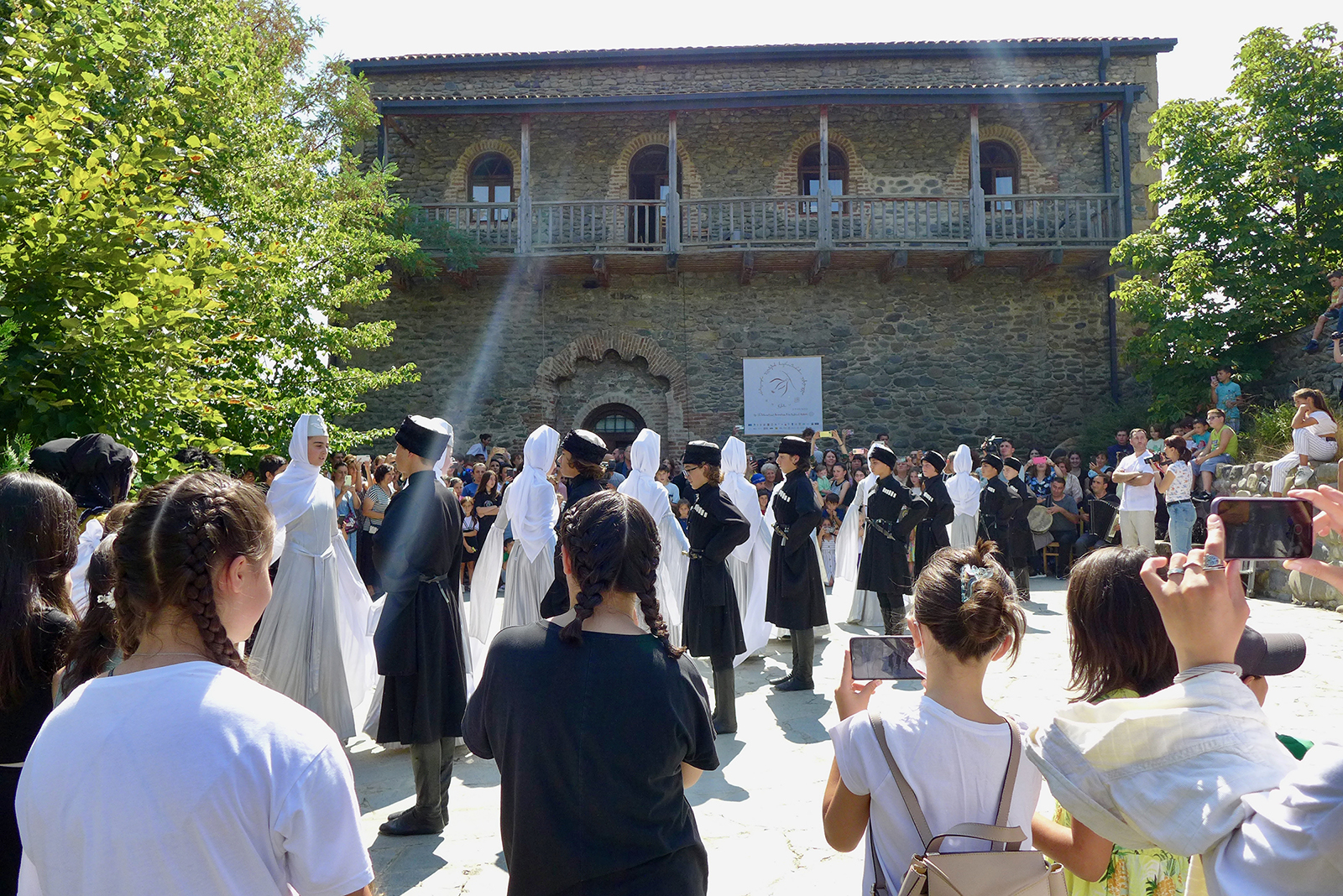 Young Georgian folk dancers from the Nikozi art school perform in front of the Episcopal Palace of the Nikozi Monastery on Sept. 1, 2023, in Nikozi, Georgia. Photo by Clément Girardot