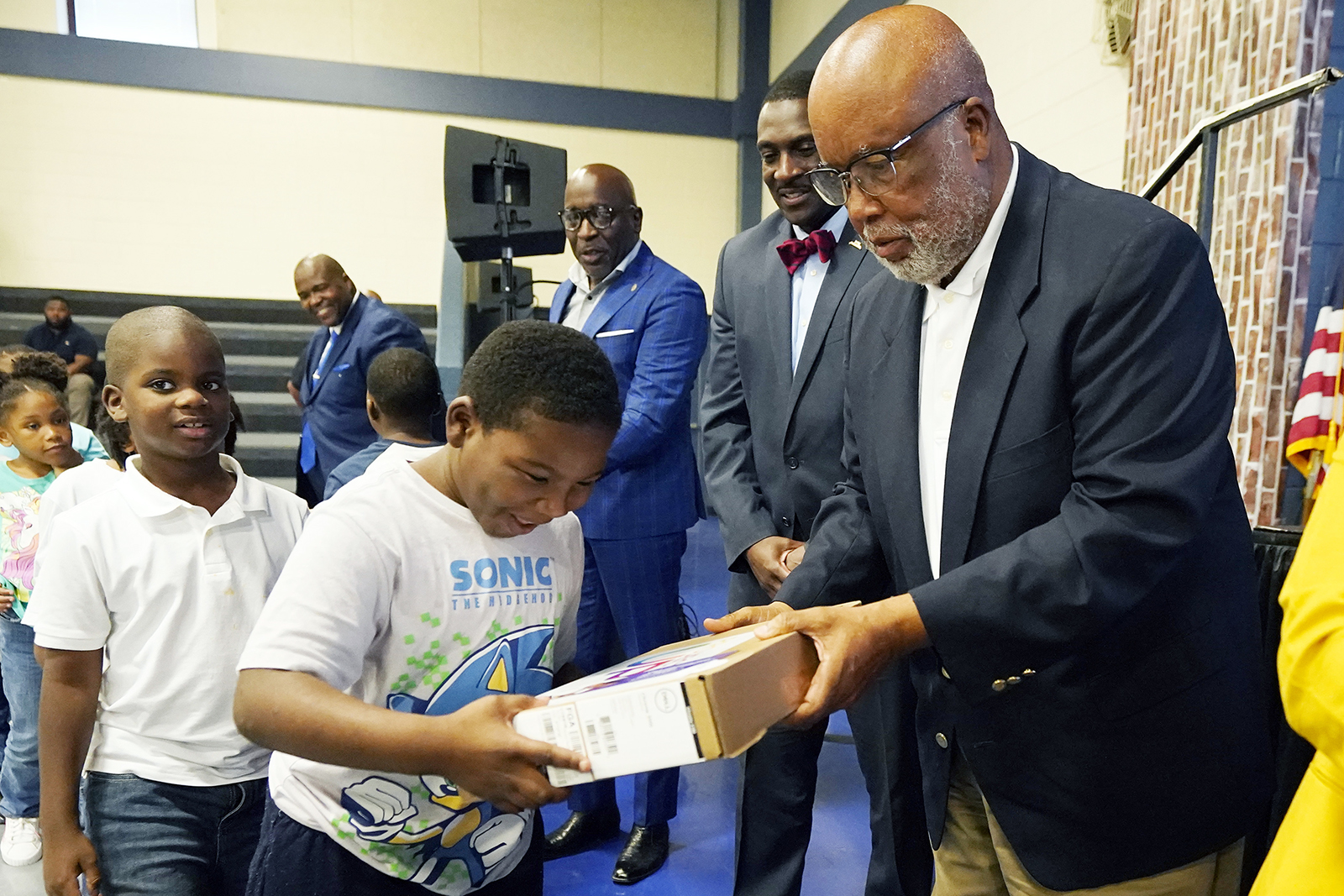U.S. Rep. Bennie Thompson, D-Miss., right, hands a Bolton-Edwards Elementary/Middle School student a new laptop during a celebration hosted by media and technology company, Comcast, announcing that they completed a broadband expansion effort in the neighboring towns of Bolton and Edwards, Tuesday, Aug. 22, 2023, in Bolton, Miss. Nearly 400 laptops were donated to students of the two schools as part of the celebration. (AP Photo/Rogelio V. Solis)