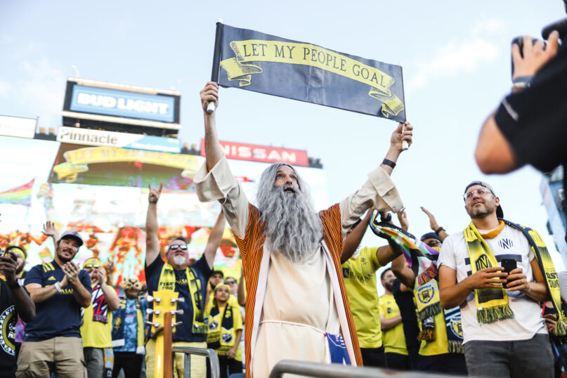 Stephen Mason attends a Nashville SC soccer game dressed as Soccer Moses with a sign bearing his catchphrase, “Let My People Goal,” in Nasvhille, Tenn. Photo by Nick Bastoky