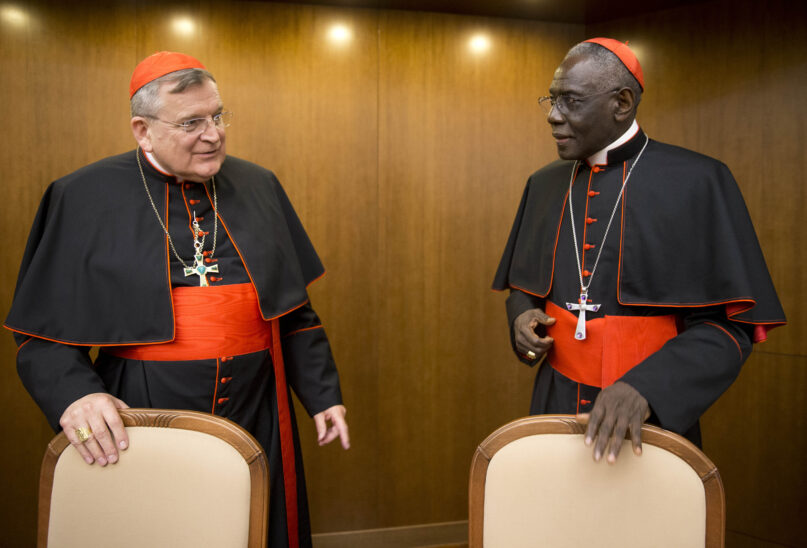 Cardinal Raymond Leo Burke, left, talks with Cardinal Robert Sarah in Rome, Oct. 14, 2015. Five conservative cardinals are challenging Pope Francis to affirm Catholic teaching on homosexuality and female ordination. They’ve asked him to respond ahead of a big Vatican meeting where such hot-button issues are up for debate.The cardinals on Monday published five questions they submitted to Francis, known as “dubia.” (AP Photo/Andrew Medichini, File)